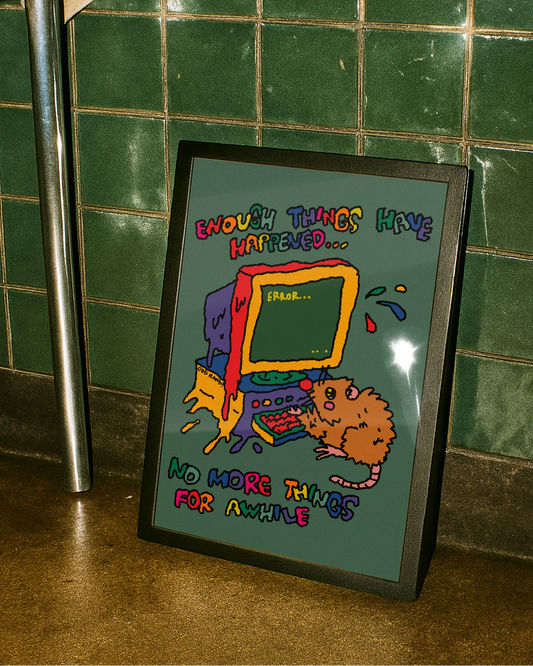 A framed art print with a colorful cartoon illustration of a rat and computer, leaning against a green tiled wall on a wooden floor.